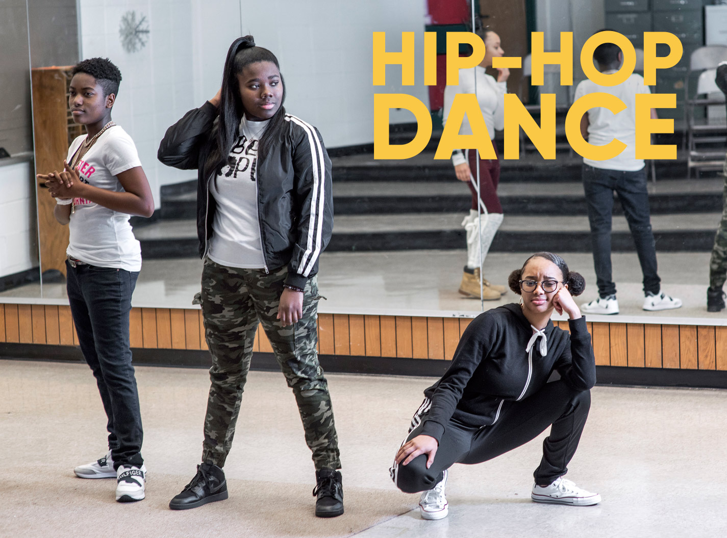 Three high school girls posing on the dance floor during hiphop dance class